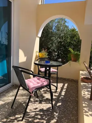 a table and chairs on a patio with a window at Lucky 5 in Paralimni