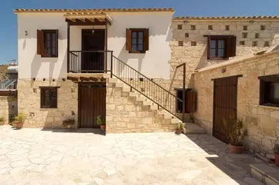 a stone house with a staircase in a courtyard at Olympia Traditional Houses in Lymbia