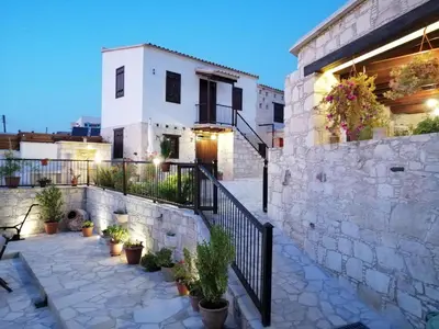 a building with a patio with potted plants at Olympia Traditional Houses in Lymbia