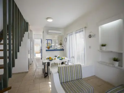 a living room with a table and a dining room at Protaras Villa Stef in Protaras