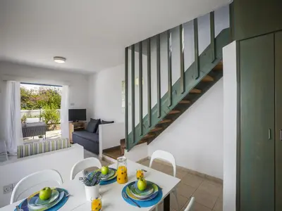 a dining room and living room with a staircase at Protaras Villa Stef in Protaras