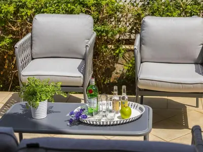 two chairs and a table with bottles and glasses at Protaras Villa Stef in Protaras