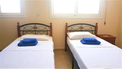two beds in a room with blue towels on them at BG06 Mythical Sands in Paralimni