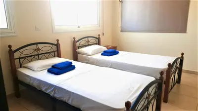 two beds in a room with blue pillows on them at BG06 Mythical Sands in Paralimni