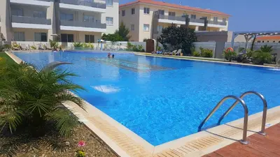 a large blue swimming pool in front of a building at BG06 Mythical Sands in Paralimni
