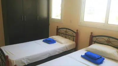 two beds in a bedroom with blue towels on them at BG06 Mythical Sands in Paralimni