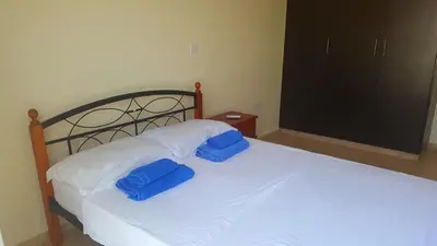two blue pillows on a white bed in a bedroom at BG06 Mythical Sands in Paralimni