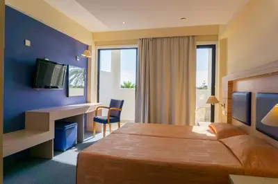 a hotel room with a bed and a desk and a television at Mariandy Hotel in Larnaka