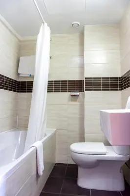 a bathroom with a tub and a toilet and a sink at Mariandy Hotel in Larnaka