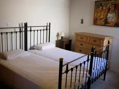 a bedroom with a bed and a dresser and a painting at Evkarpos Country House in Psematismenos
