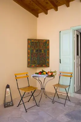 a table with two chairs and a table with vegetables on it at Evkarpos Country House in Psematismenos