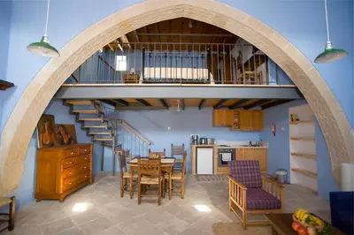a kitchen and dining room with an archway in a house at Evkarpos Country House in Psematismenos