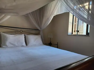 a bedroom with a bed with white sheets and a window at Vrakas House in Tochni