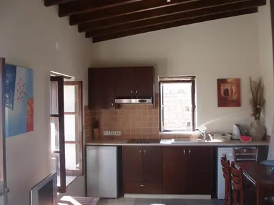 a kitchen with brown cabinets and a sink and a window at Vrakas House in Tochni