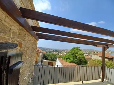 a view from the balcony of a house with a wooden pergola at Kleanthis House in Tochni