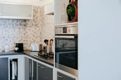 a kitchen with a stove and a microwave at Lazaros Centre Apartment in Larnaka