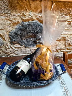 a bottle of wine in a bag on a table at Eleni's Cottage in Apsiou