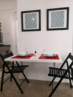 a white table with two chairs and glasses on it at Cheerful Apartment in Nicosia in Yukarı Lakatamya
