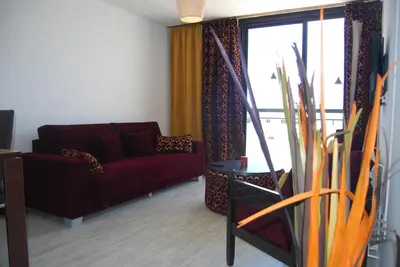 a living room with a red couch and a window at Agrino Hotel Apartments in Ayia Napa