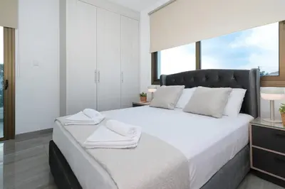 a bedroom with a large white bed with towels on it at Villa Calliopi in Protaras