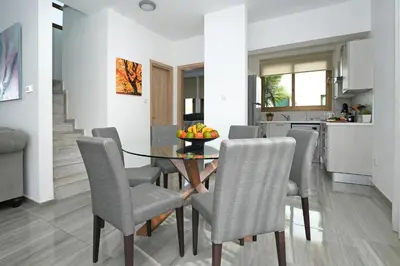 a kitchen and dining room with a table and chairs at Villa Calliopi in Protaras