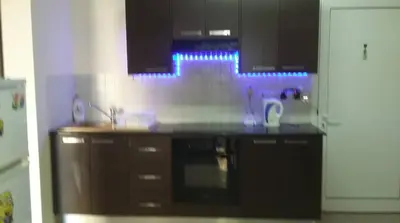 a kitchen with a stove and a sink with blue lights at Hermes complex1 paralimni in Paralimni