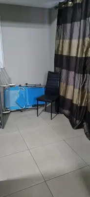 a black chair sitting in a room with a curtain at Hermes Complex 2 Paralimni Cyprus in Paralimni