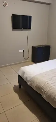 a bedroom with a bed and a flat screen tv at Hermes Complex 2 Paralimni Cyprus in Paralimni