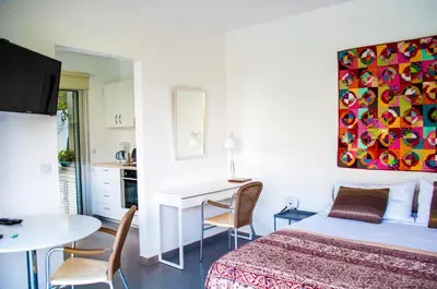 a bedroom with a bed and a desk and a table at Idyllic studio with private pool in Nicosia
