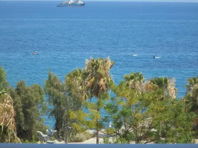 a view of the ocean with people in boats at Kermia Court - Beach-front, modern 2 bedroom -sleeps 6 in Limassol