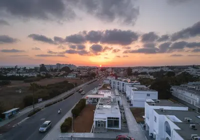 a sunset over a city with a road and buildings at Kaos Hotel Apartments in Ayia Napa