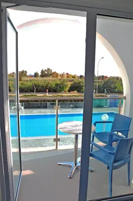 a patio with a table and chairs and a pool at Kaos Hotel Apartments in Ayia Napa