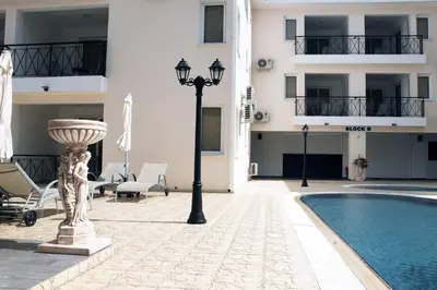 a hotel with a pool and a street light next to a building at Carisa Livadia Gardens in Livadhia