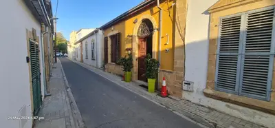 an empty street with a yellow and white building at Petro's Antique House in Nicosia