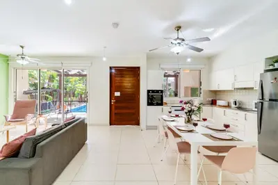 a kitchen and living room with a couch and a table at Villa Venus by Ezoria Villas in Pervolia