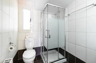 a bathroom with a toilet and a glass shower at Villa Venus by Ezoria Villas in Pervolia