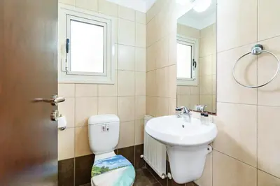 a bathroom with a toilet and a sink at Villa Venus by Ezoria Villas in Pervolia