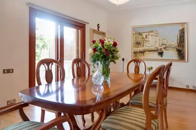 a dining room table with a vase of flowers on it at Limassol Beachfront Holiday Villa in Limassol