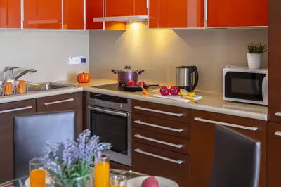 a kitchen with a stove and a microwave at one bedroom apartment in Fig tree bay in Protaras