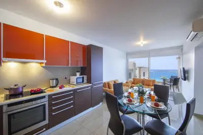 a kitchen and living room with a table and chairs at one bedroom apartment in Fig tree bay in Protaras
