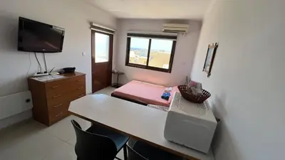 a small room with a desk and a bed at Elena Court Apartments in Ayia Napa