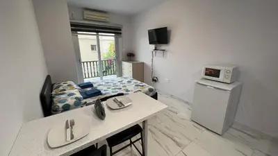a small room with a bedroom with a bed and a table at Elena Court Apartments in Ayia Napa