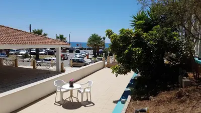 a table and two chairs on a patio with a parking lot at ZORBAS Sea View No 4 in Larnaka