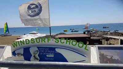 a sign for a wind surf school on the beach at ZORBAS Sea View No 4 in Larnaka
