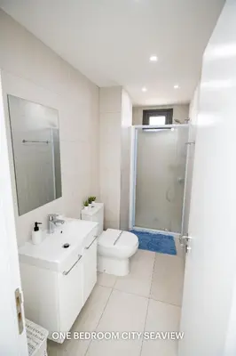 a white bathroom with a toilet and a shower at Lazuli City & Seaview Apartments in Larnaka