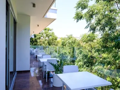 a row of white tables and chairs on a balcony at Rio Gardens Aparthotel in Ayia Napa