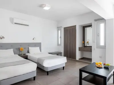 a hotel room with two beds and a table at Rio Gardens Aparthotel in Ayia Napa