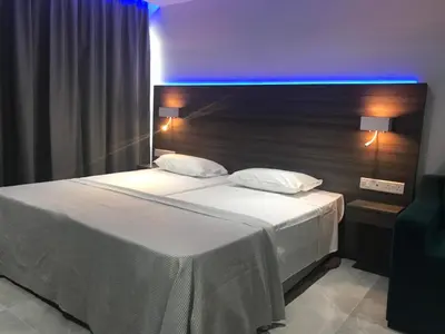 a bedroom with a white bed with a blue light at Rio Gardens Aparthotel in Ayia Napa