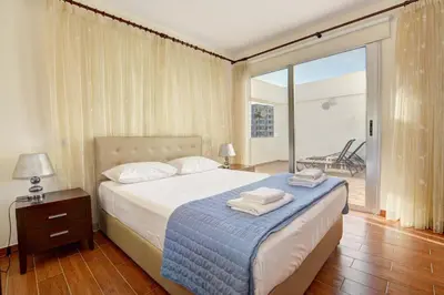 a bedroom with a bed with towels on it at Seafront Protaras Apartments in Protaras