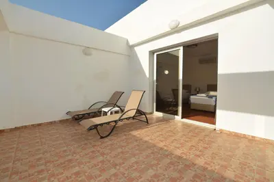 a room with two chairs and a bedroom at Seafront Protaras Apartments in Protaras